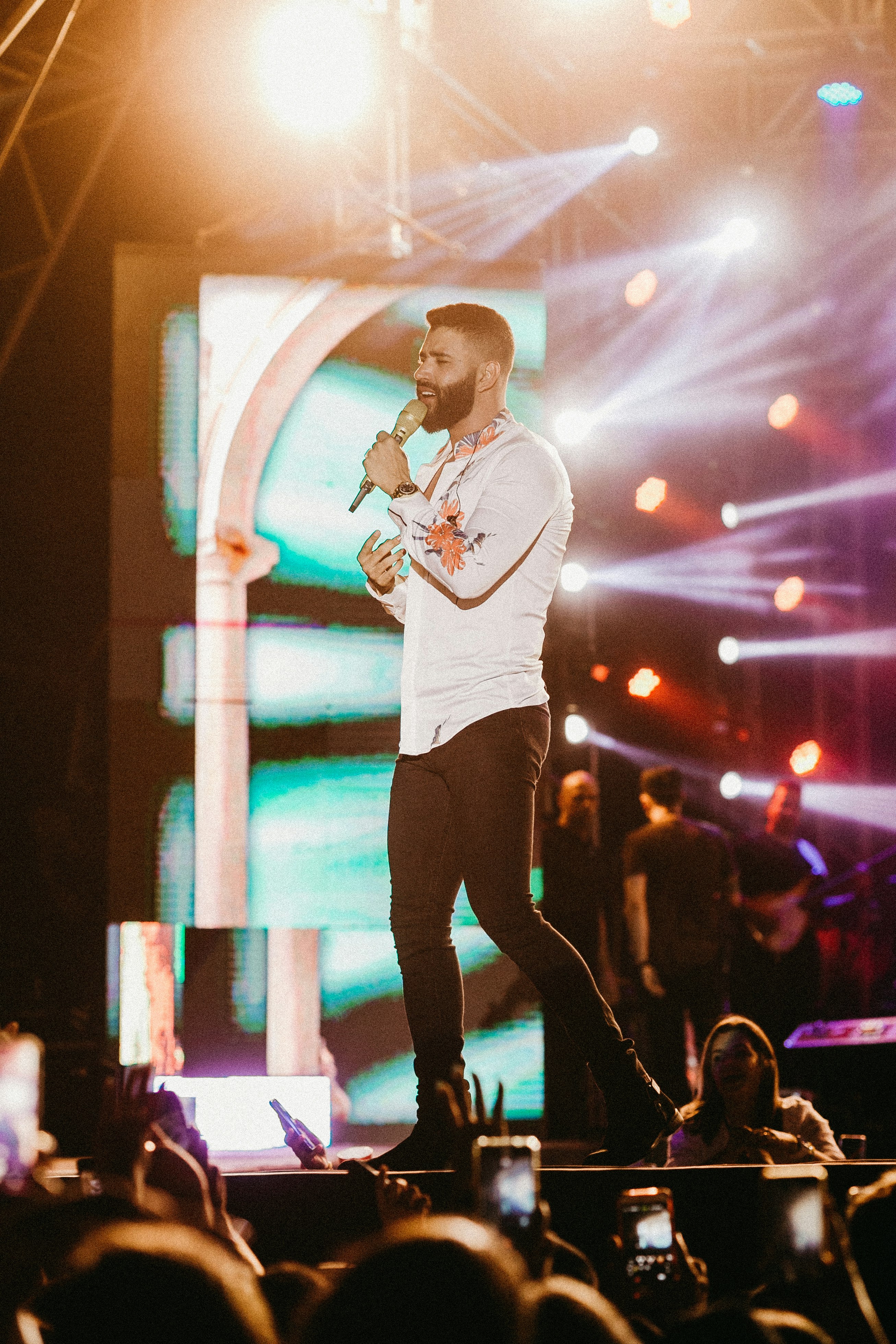 man in white sweater singing on stage